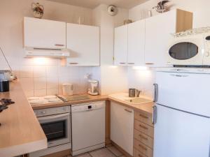 a kitchen with white cabinets and a white refrigerator at Apartment Les Flots Cypriano by Interhome in Saint-Cyprien-Plage