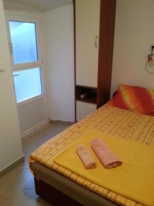 1 dormitorio con 1 cama con 2 toallas en Apartments Previšić, en Cavtat