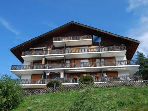 un gran edificio con balcones en la cima de una colina en Apartment Beausoleil H by Interhome, en Veysonnaz