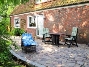 een patio met een tafel en stoelen en een bakstenen gebouw bij Apartment Haus am See by Interhome in Hohenkirchen