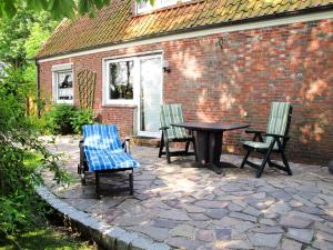 HohenkirchenにあるApartment Haus am See by Interhomeのレンガ造りの建物で、パティオ(テーブル、椅子付)