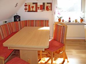 HohenkirchenにあるApartment Haus am See by Interhomeの木製のテーブルと椅子のあるダイニングルーム