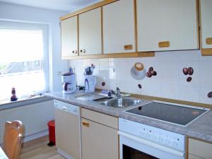 HohenkirchenにあるApartment Haus am See by Interhomeの白いキャビネットとシンクのあるキッチン