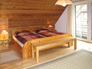 ホークジールにあるHoliday Home Johanna by Interhomeのベッドルーム1室(大型木製ベッド1台、ベンチ付)