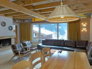 sala de estar con sofá, mesa y sillas en Apartment Chalet Casa Almis 5 by Interhome, en Grindelwald