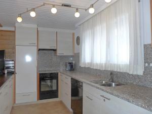 a kitchen with white cabinets and a sink at Apartment Chalet Almis 5 by Interhome in Grindelwald
