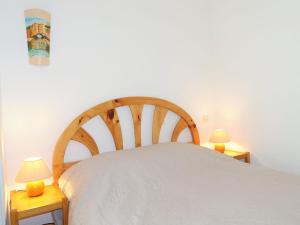 a bedroom with a white bed with two lamps at Apartment Les Balcons de la Méditerranée-16 by Interhome in Narbonne-Plage