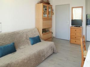sypialnia z łóżkiem z niebieskimi poduszkami i telewizorem w obiekcie Apartment Les Balcons de la Méditerranée-16 by Interhome w mieście Narbonne-Plage