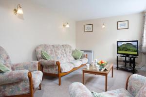a living room with a couch and a tv at Low Croft Cottage in Grasmere