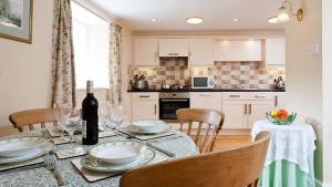 a kitchen with a table with a bottle of wine at Low Croft Cottage in Grasmere