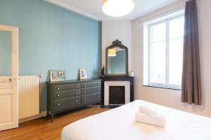 a bedroom with a bed and a mirror and a fireplace at Le chic d'Adam in Nancy