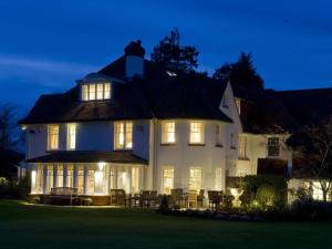 a large white house with lights on at night at Park House Hotel in Midhurst