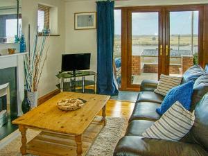a living room with a couch and a coffee table at Crud yr Awel in Y Felinheli