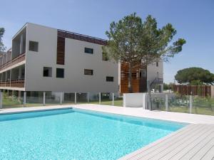 a house with a swimming pool in front of a building at Apartment Le Golf Clair-1 by Interhome in Saint-Cyprien