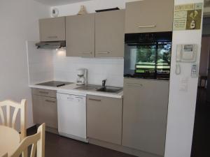 a small kitchen with a sink and a refrigerator at Apartment Le Golf Clair-1 by Interhome in Saint-Cyprien