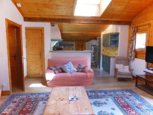 sala de estar con sofá rosa y mesa de madera en Apartment Les Moranches by Interhome, en Les Contamines-Montjoie