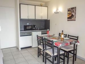 a kitchen with a table and chairs and a kitchen with white cabinets at Apartment Les Aigues Marines by Interhome in La Madrague