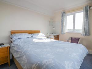 a bedroom with a large bed and a window at Yellow Sands Apartment 7 in Padstow