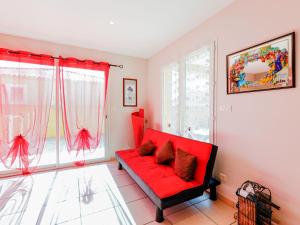 a living room with a red couch in front of a window at Villa l'Occitane by Interhome in Agde +18 photos