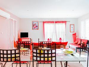 un soggiorno con mobili rossi, tavolo e sedie di Villa l'Occitane by Interhome ad Agde