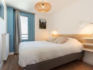a bedroom with a large bed and a window at Apartment Le Curling A-9 by Interhome in Tignes