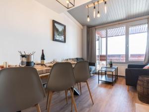 a living room with a dining room table and chairs at Apartment Le Curling A-9 by Interhome in Tignes