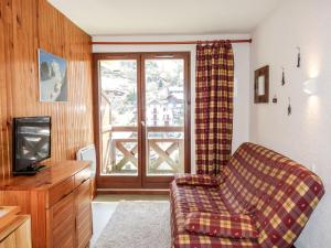 a living room with a couch and a tv and a window at Apartment Les Hauts de St Gervais-3 by Interhome in Saint-Gervais-les-Bains