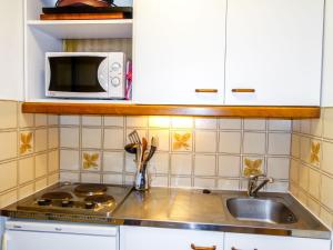 a kitchen with a sink and a microwave at Apartment Les Hauts de St Gervais-3 by Interhome in Saint-Gervais-les-Bains