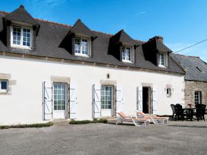 a white house with a table and chairs in front of it at Holiday Home Ty Coz - PZV 106 by Interhome in Plozévet