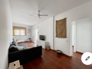 Una sala de estar con un sofá y un televisor. en Casa Pita, en San José