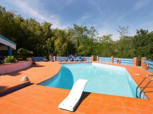 a large swimming pool with a tile floor and a brick patio at Villa La Chiazza by Interhome in Corsanico-Bargecchia