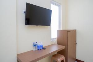a room with a flat screen tv on a wall at RedDoorz near Tugu Muda Semarang in Kalibanteng-lor