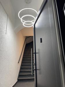 a hallway with a door and a staircase with a chandelier at BASSWOOD ROOMS in Bremen +16 photos