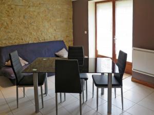 uma sala de jantar com uma mesa e cadeiras e um sofá em Holiday Home Saint Avit - DGC400 by Interhome em Dégagnac