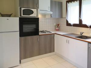 uma cozinha com um fogão e um micro-ondas em Holiday Home Saint Avit - DGC400 by Interhome em Dégagnac