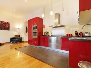 a kitchen with red cabinets and a counter top at Keswick Loft in Keswick