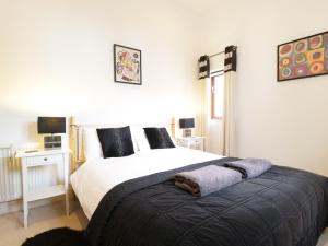 a bedroom with a large white bed with black pillows at Keswick Loft in Keswick