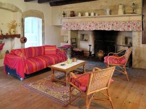 sala de estar con sofá rojo y chimenea en Holiday Home Le Mas de Serre by Interhome, en Nuzéjouls