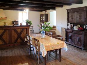 a kitchen with a table with a vase of flowers on it at Holiday Home Le Mas de Serre by Interhome in Nuzéjouls +16 photos