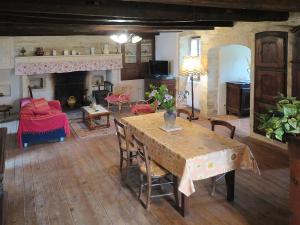 a living room with a table and a fireplace at Holiday Home Le Mas de Serre by Interhome in Nuzéjouls