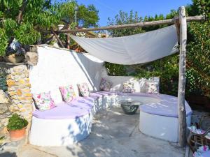 eine Terrasse im Hinterhof mit einer Bank und einem Baldachin in der Unterkunft Holiday Home Fontanarosa by Interhome in SantʼAgata sui Due Golfi