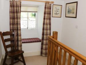 LevensにあるCoachmans Cottageの窓、ベンチ、椅子が備わる客室です。