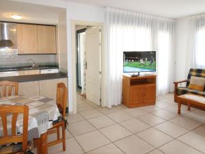 cocina y sala de estar con mesa y TV en Apartment Tamarindo by Interhome, en Cala de Finestrat