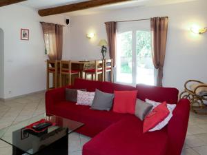 uma sala de estar com um sofá vermelho e uma mesa em Holiday Home Sweet Home in Luberon - VLU100 by Interhome em Villelaure