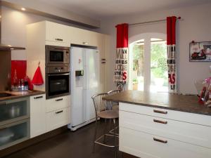 uma cozinha com armários brancos e um frigorífico branco em Holiday Home Sweet Home in Luberon - VLU100 by Interhome em Villelaure