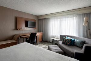 a hotel room with a bed and a desk and a couch at Sonesta Select Tempe Downtown in Tempe