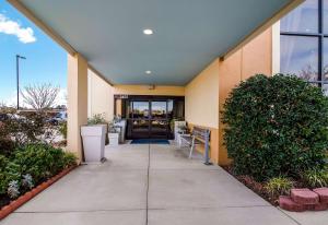 a walkway leading to a building with a door at Clarion Pointe New Bern in New Bern