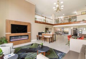 an open living room with a fireplace and a dining room at Clarion Pointe New Bern in New Bern