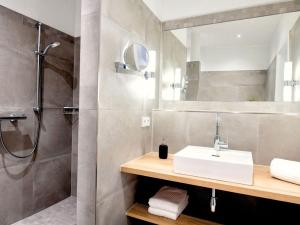 a bathroom with a sink and a shower at Hotel Busch in Westerstede