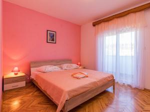 a bedroom with a bed with pink walls and a window at Holiday Home Larisa - IPC141 by Interhome in Pićan